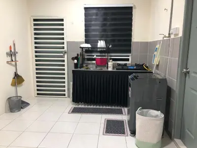 a kitchen with a counter and a refrigerator at Teratak Arissa Homestay in Sitiawan