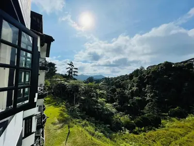 a view from the side of a building looking out at a forest at A Highland Retreat in Tanah Rata in Tanah Rata