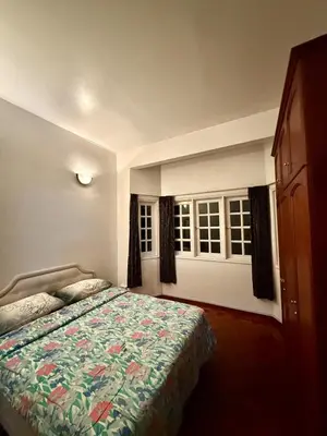 a bedroom with a bed and two windows at A Highland Retreat in Tanah Rata in Tanah Rata