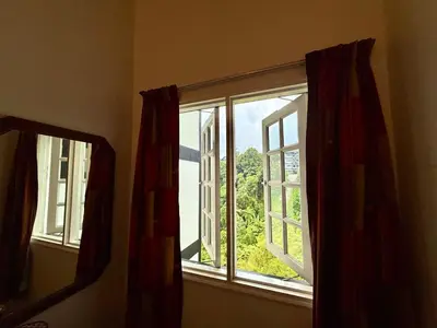 a window with red curtains in a room at A Highland Retreat in Tanah Rata in Tanah Rata