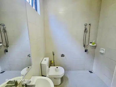 a white bathroom with a toilet and a sink at Cozy Villa - Private Pool, 5BR, KTV, BBQ, PS5 just 3 Mins to Batu Ferringhi Beach! in Batu Ferringhi