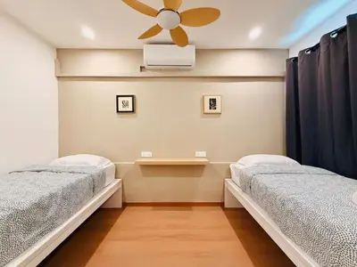 two beds in a room with a ceiling fan at WhiteZen Family Homestay 9Room for 20pax Central Penang in Jelutong