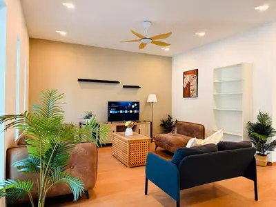 a living room with a couch and a tv at WhiteZen Family Homestay 9Room for 20pax Central Penang in Jelutong
