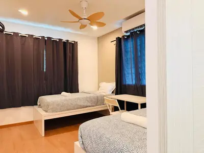 a room with two beds and a ceiling fan at WhiteZen Family Homestay 9Room for 20pax Central Penang in Jelutong