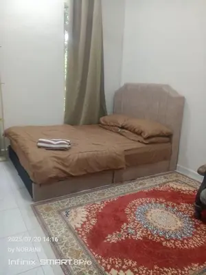 a bed in a bedroom with a rug on the floor at Aisyah Homestay in Kuala Ketil