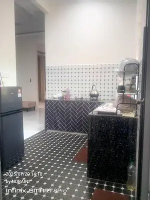 a kitchen with a black and white tiled floor at Aisyah Homestay in Kuala Ketil