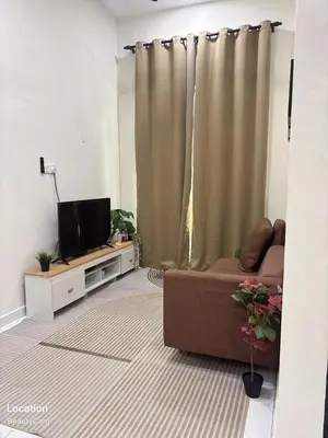 a living room with a couch and a television at Aisyah Homestay in Kuala Ketil