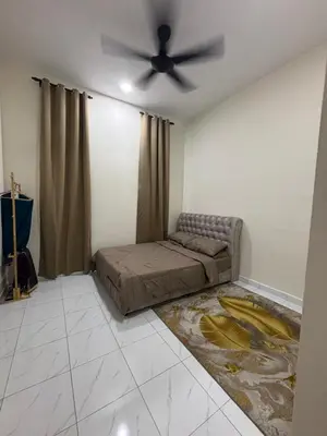 a bedroom with a bed and a ceiling fan at Aisyah Homestay in Kuala Ketil
