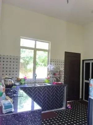 a kitchen with a counter with a sink and a window at Aisyah Homestay in Kuala Ketil