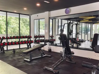 a gym with lots of exercise equipment and windows at The Cove Hillside Residence Ipoh by PLY Home in Ipoh