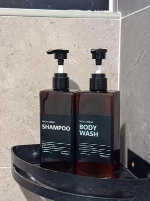 two bottles of shampoo and body wash sitting on a shelf at The Cove Hillside Residence Ipoh by PLY Home in Ipoh