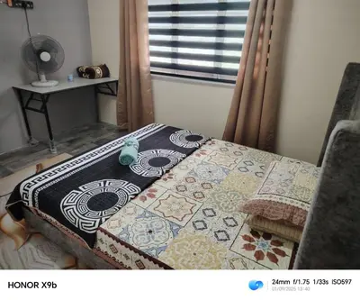 a table with a quilt on it in a room at Ed 02 manjung in Seri Manjung