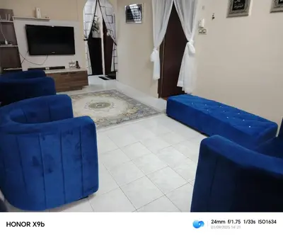a living room with blue chairs and a tv at Ed 02 manjung in Seri Manjung