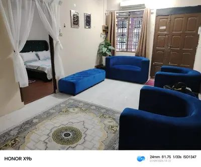 a living room with blue chairs and a bed at Ed 02 manjung in Seri Manjung