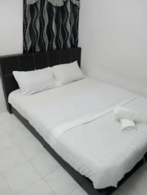 a bed with white sheets and pillows in a room at Dynamic smartstay in Ipoh