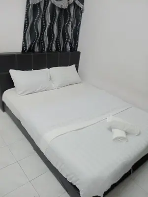 a bed with white sheets and pillows on it at Dynamic smartstay in Ipoh