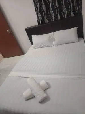 a white bed with two towels on top of it at Dynamic smartstay in Ipoh