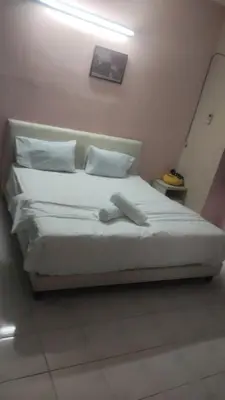 a bed with white sheets and pillows in a room at Dynamic smartstay in Ipoh