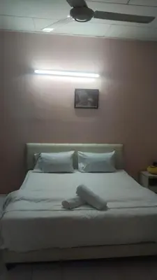 a bed with white sheets and pillows in a room at Dynamic smartstay in Ipoh