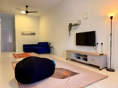 a living room with a blue couch and a tv at 28 Harmoni Homestay, Kamunting in Kamunting