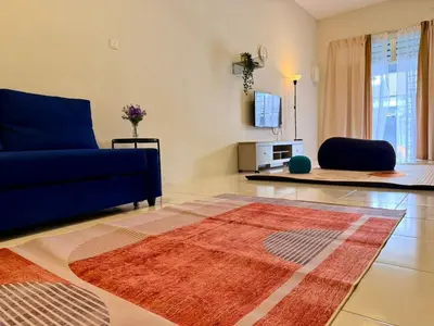 a living room with a blue couch and a rug at 28 Harmoni Homestay, Kamunting in Kamunting