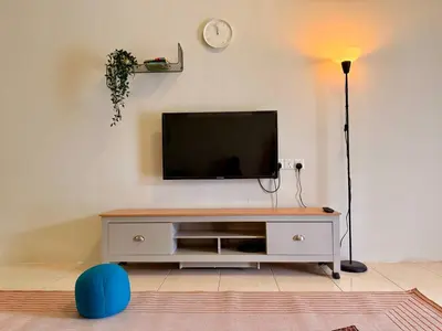 a living room with a flat screen tv on a white cabinet at 28 Harmoni Homestay, Kamunting in Kamunting