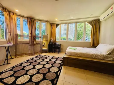 a bedroom with a bed and a table and windows at Family Fun Private Pool Villa with KTV, BBQ, PS5, POOL TABLE, KITCHEN just 2-Minute Drive to Tanjung Bungah Beach in Tanjung Bungah