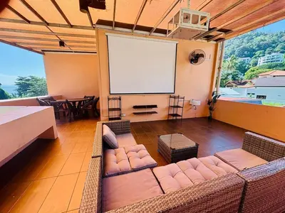 a living room with a couch and a projection screen at Family Fun Private Pool Villa with KTV, BBQ, PS5, POOL TABLE, KITCHEN just 2-Minute Drive to Tanjung Bungah Beach in Tanjung Bungah