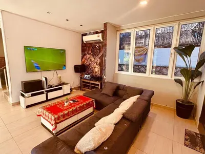 a living room with a couch and a flat screen tv at Family Fun Private Pool Villa with KTV, BBQ, PS5, POOL TABLE, KITCHEN just 2-Minute Drive to Tanjung Bungah Beach in Tanjung Bungah
