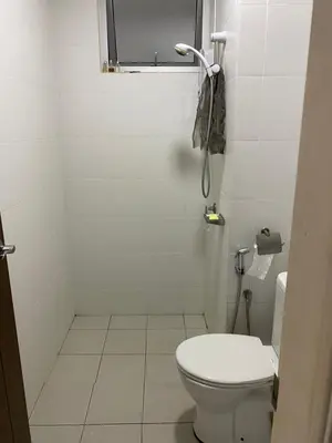 a white bathroom with a toilet and a window at 1 room at my apartment at Chez Marcel in Tanjung Bungah