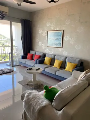 a living room with a blue couch with colorful pillows at 1 room at my apartment at Chez Marcel in Tanjung Bungah