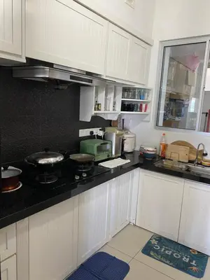 a kitchen with white cabinets and a black counter top at 1 room at my apartment at Chez Marcel in Tanjung Bungah