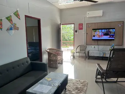 a living room with a couch and a tv at Chengai Homestay in Sungkai