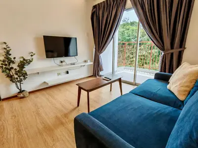 a living room with a blue couch and a tv at DawnBlue Cameron Highlands in Brinchang