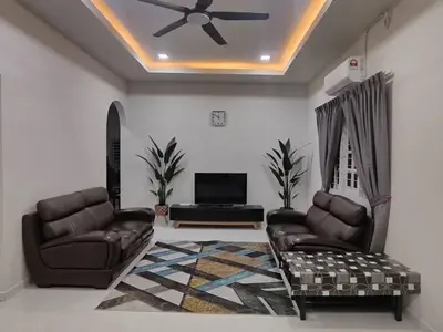 a living room with two chairs and a ceiling fan at Rumah Pak Syed in Ipoh