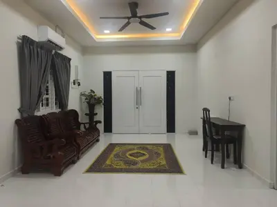 a living room with a ceiling fan and a chair and a rug at Rumah Pak Syed in Ipoh