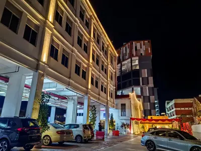 a parking lot with cars parked in front of a building at C Y C Heritage Hotel in George Town