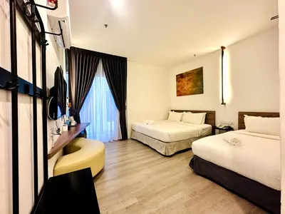 a hotel room with two beds and a television at C Y C Heritage Hotel in George Town