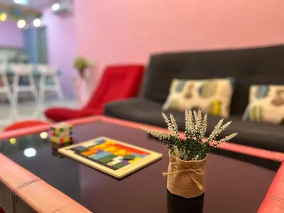 a living room with a table with a vase with flowers at Sky Garden Ipoh Comfortable Homestay 6-7pax SY27 in Chemor