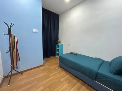 a bedroom with a green bed and a blue wall at Sky Garden Ipoh Comfortable Homestay 6-7pax SY27 in Chemor