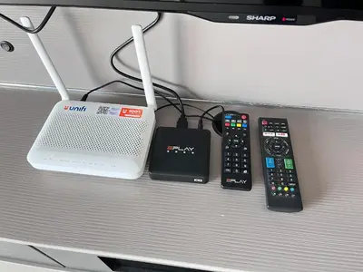 three remote controls and a router sitting on a bench at FY Perumahan Makmur TR Jaya Tanah Rata in Tanah Rata