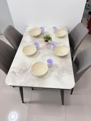 a table with plates and cups and a plant on it at FY Perumahan Makmur TR Jaya Tanah Rata in Tanah Rata