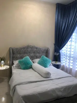 a bedroom with a bed with blue pillows and a window at DQis Nest Casa Apartment in Chemor