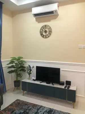 a living room with a flat screen tv and a fan at DQis Nest Casa Apartment in Chemor