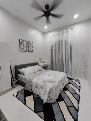 a bedroom with a bed and a ceiling fan at Arjuna Homestay - Batu Gajah in Batu Gajah