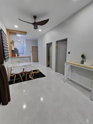 a living room with a ceiling fan and a table at Arjuna Homestay - Batu Gajah in Batu Gajah