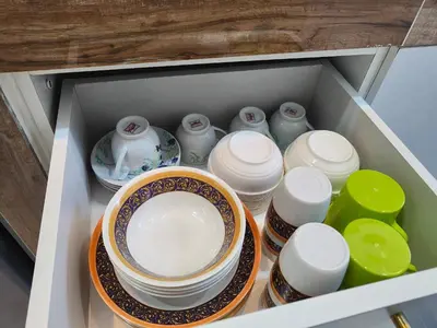 a drawer full of dishes and bowls in a cabinet at Arjuna Homestay - Batu Gajah in Batu Gajah