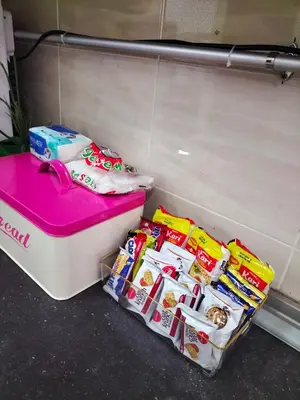 a pink and white cooler sitting next to some snacks at Homestay Ustaz in Batu Gajah