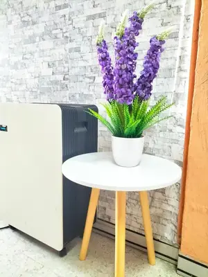 a white table with a vase of purple flowers on it at Homestay Ustaz in Batu Gajah