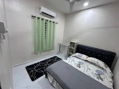 a bedroom with a bed and a green curtain at Anjang Pat Kesang Laut Homestay in Gua Sai